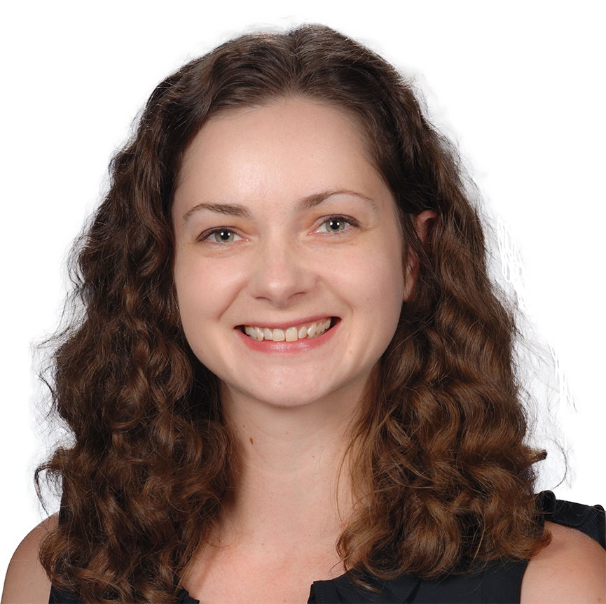 Headshot of a person with shoulder-length curly brown hair, wearing a sleeveless black top against a white background.