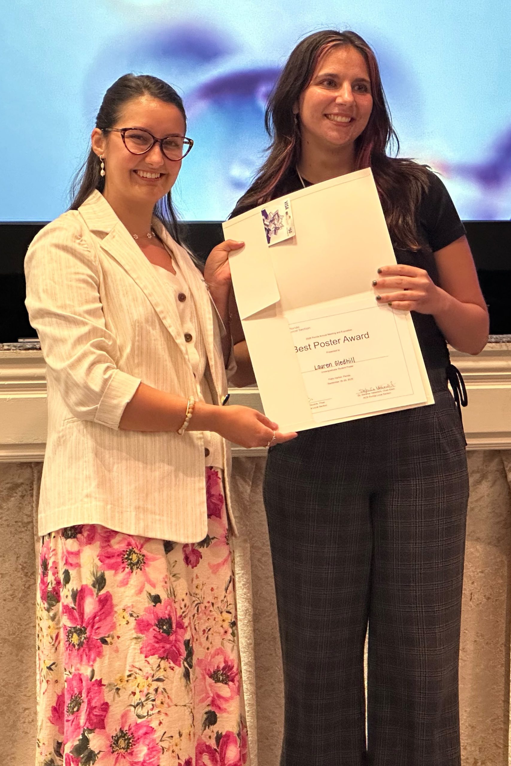 Lauren Gledhill (right) accepts her Best Poster Award certificate from FL-ACS Treasurer Ashlyn Hale (left) at FAME 2026.